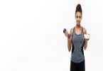 Healthy and Fitness concept - Beautiful sporty African American on diet holding dumbbell and fresh salad on hands. Isolated on white studio background.
